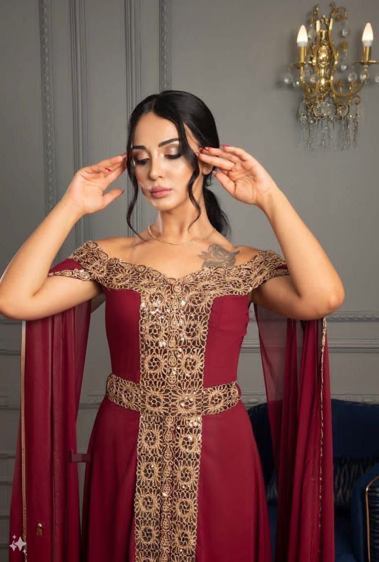 فستان سهرة بورجوندي بدون أكتاف مزين بتطريزات.